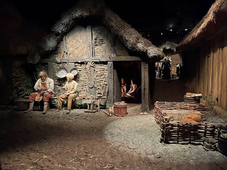 A group of people sitting in a hut
Description automatically generated